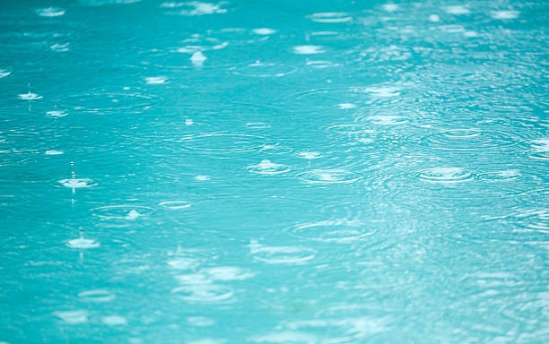 Freibad bei Regen Regentropfen auf Wasserfläche