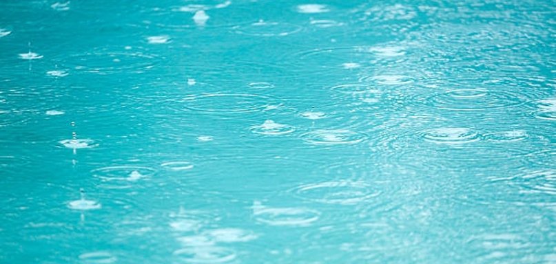 Regentropfen auf Wasserfläche