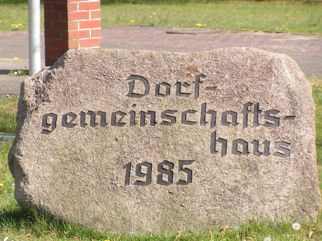 Stein Dorfgemeinschaftshaus Grauen Findling als Hinweis